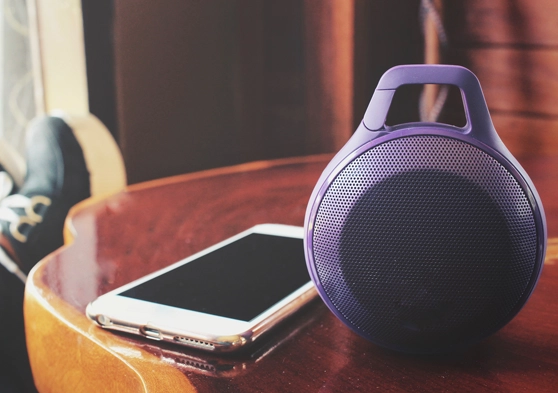 Smartphone junto a un altavoz apoyados en una mesa